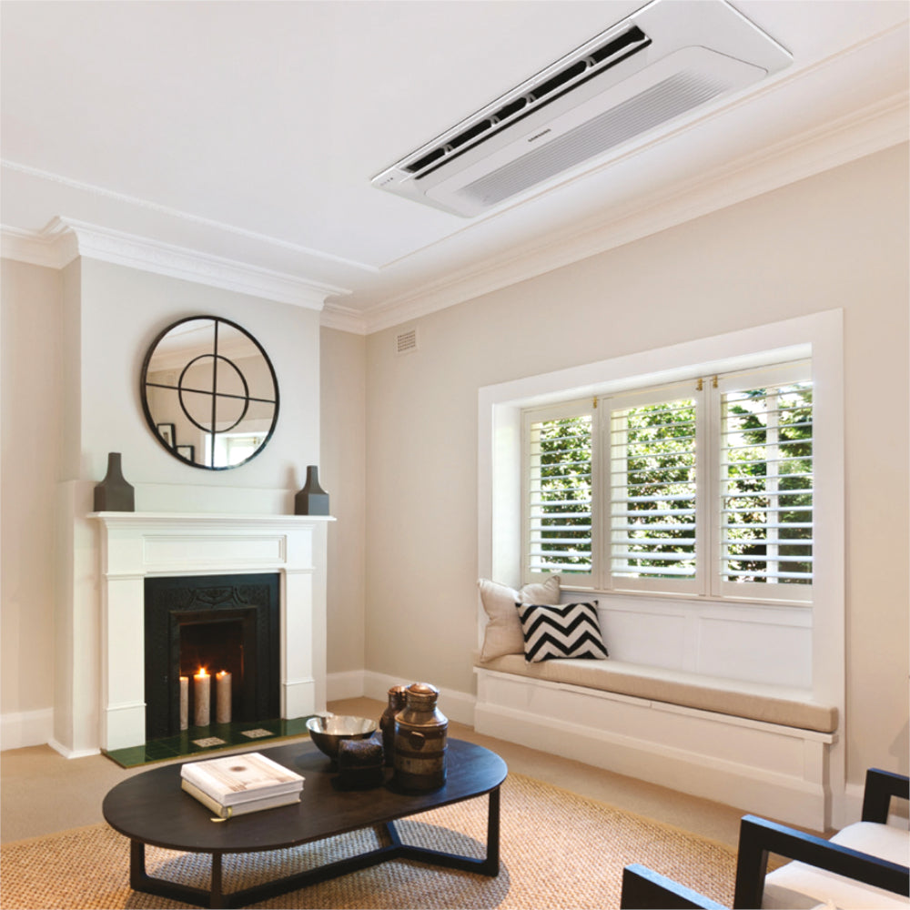 Ambientebild: Samsung WindFree 1-Wege-Deckenkassette in Weiss, montiert in hellem Wohnzimmer mit Kamin und Fensterbank | Klimaworld.com